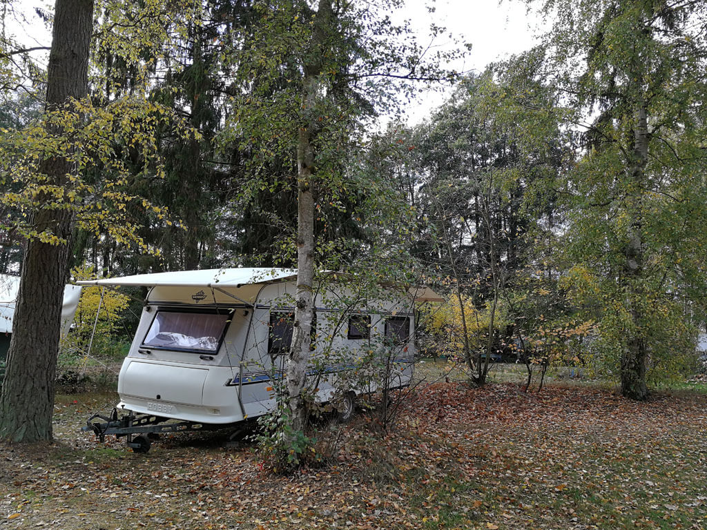Stellplatz Hobby Wohnwagen unter Bäumen am Rätzsee